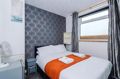 a bedroom with a bed with two towels on it at Derwent Holiday Hotel in Blackpool