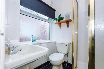 a bathroom with a toilet and a sink and a window at Derwent Holiday Hotel in Blackpool