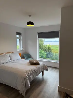 a bedroom with a large bed and a large window at Seaside escape near Cartmel and Grange in Kents Bank