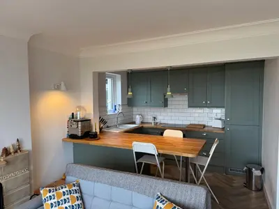 a kitchen with green cabinets and a wooden counter top at Seaside escape near Cartmel and Grange in Kents Bank