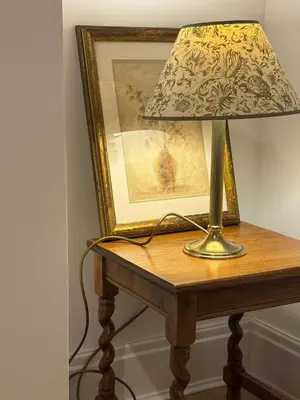 a lamp on a table next to a picture at Modernised fisherman's house near Lytham centre in Brown Moss Side