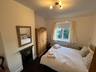 a bedroom with a bed and a mirror on the wall at Modernised fisherman's house near Lytham centre in Brown Moss Side
