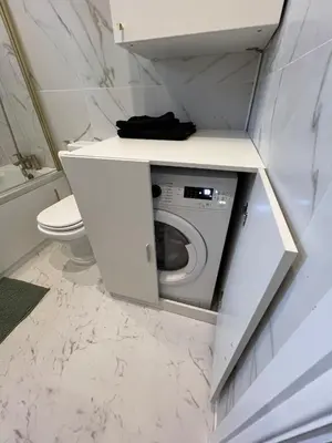 a bathroom with a washing machine in a cabinet at Modernised fisherman's house near Lytham centre in Brown Moss Side