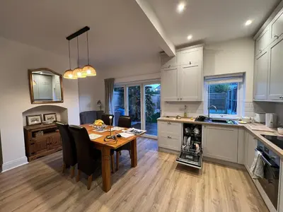 a kitchen and dining room with a wooden table at Modernised fisherman's house near Lytham centre in Brown Moss Side