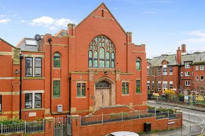 a large red brick building with a large door at Luna Church 5 Blackpool in Blackpool