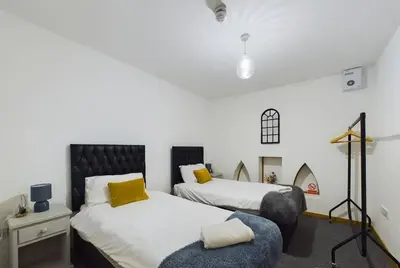 a bedroom with two beds and a chair at Luna Church 5 Blackpool in Blackpool