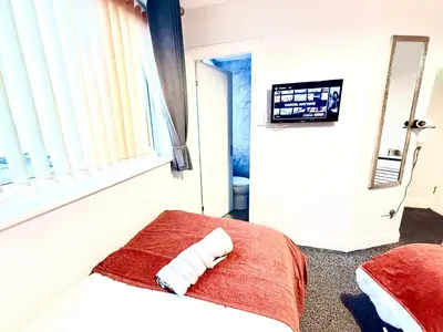 a bedroom with a bed and a window and a television at Cherish Lewis Hotel Blackpool in Blackpool