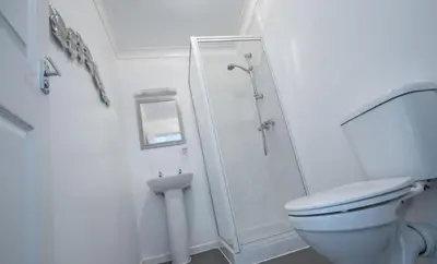 a white bathroom with a shower and a toilet at Cherish Lewis Hotel Blackpool in Blackpool