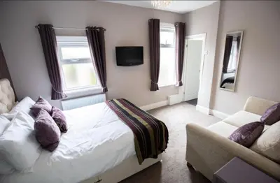 a bedroom with a bed and a couch at Cherish Lewis Hotel Blackpool in Blackpool