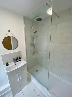 a bathroom with a glass shower and a sink at Modern Bungalow Family Friendly and Eco-Conscious in Southport