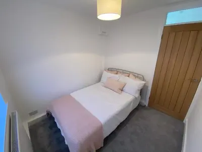 a small bedroom with a bed and a door at Modern Bungalow Family Friendly and Eco-Conscious in Southport