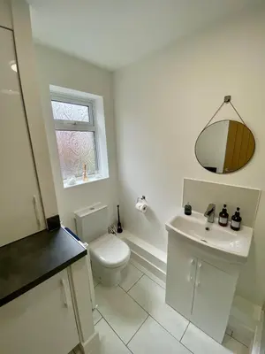 a white bathroom with a toilet and a sink at Modern Bungalow Family Friendly and Eco-Conscious in Southport