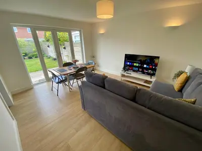 a living room with a couch and a table and a television at Modern Bungalow Family Friendly and Eco-Conscious in Southport
