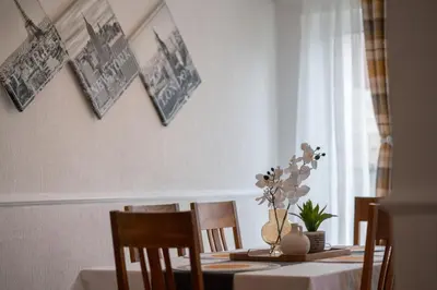 a dining room table with a vase of flowers on it at Spacious 3BR House By Kammili Properties in Westhoughton - Free Parking in Westhoughton