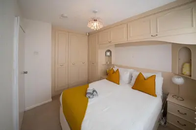 a bedroom with a large white bed with yellow pillows at Spacious 3BR House By Kammili Properties in Westhoughton - Free Parking in Westhoughton