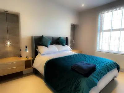 a bedroom with a large bed with a blue blanket at Design-inspired, Stunning Clitheroe Home in Clitheroe