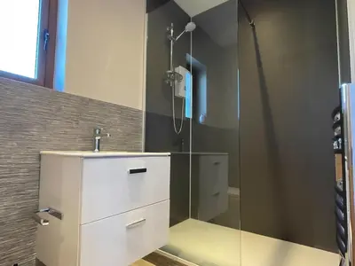 a bathroom with a shower with a sink and a mirror at Design-inspired, Stunning Clitheroe Home in Clitheroe