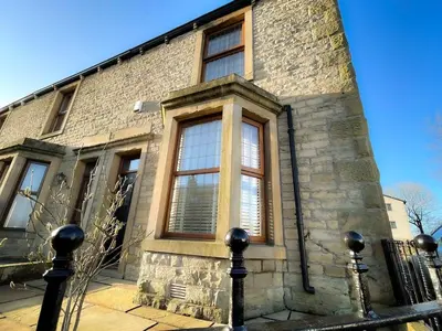 a brick building with windows and a fence at Design-inspired, Stunning Clitheroe Home in Clitheroe