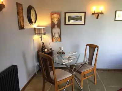 a dining room with a glass table and two chairs at Artie's Lodge in Arnside