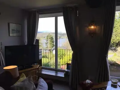 a living room with a large window with a view at Artie's Lodge in Arnside