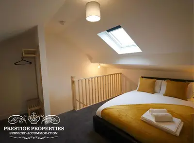 a bedroom with a large bed with a skylight at 30 Telford St by Prestige Properties SA in Barrow in Furness