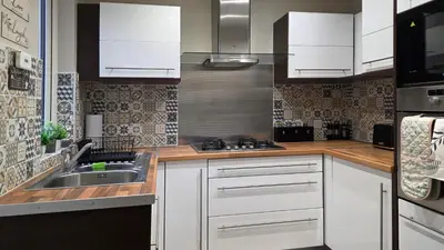 a kitchen with white cabinets and a sink at 3 bedroom modern newly renovated house in Preston in Preston