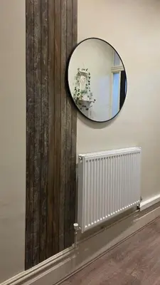 a mirror on a wall next to a radiator at 3 bedroom modern newly renovated house in Preston in Preston