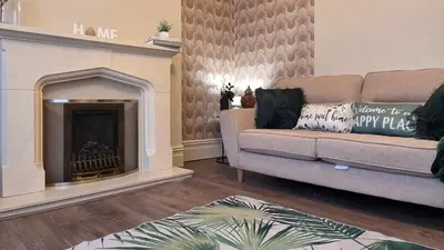 a living room with a couch and a fireplace at 3 bedroom modern newly renovated house in Preston in Preston