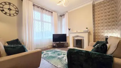 a living room with a fireplace and a tv at 3 bedroom modern newly renovated house in Preston in Preston