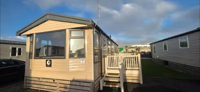 a tiny house with a porch and a trailer at Mason's Morecambe Memories in Heysham