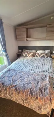 a bedroom with a bed with a colorful comforter at Mason's Morecambe Memories in Heysham