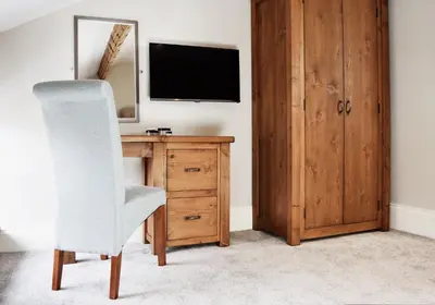 a room with a desk with a television and a chair at The Morecambe Hotel in Morecambe