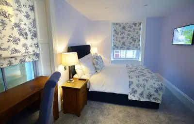 a bedroom with a bed and a desk and a window at The Morecambe Hotel in Morecambe
