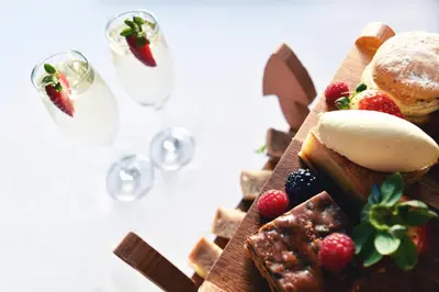 a plate of food with desserts and glasses of wine at The Morecambe Hotel in Morecambe