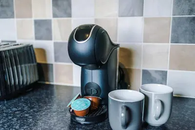 a coffee maker sitting on a counter with two cups at St Helens Central, 2 Bed , Long Stay OFFERS, Contractors, Relocations, Families, Sleeps 4 Banner Street 10, St Helens in Saint Helens