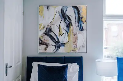 a bedroom with a blue couch and a painting on the wall at St Helens Central, 2 Bed , Long Stay OFFERS, Contractors, Relocations, Families, Sleeps 4 Banner Street 10, St Helens in Saint Helens
