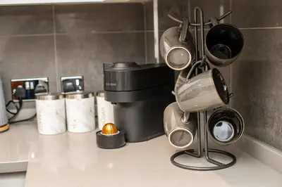 a kitchen counter with pots and pans and cups at Superb Location Stunning Luxury 4 Bedroom House in Liverpool