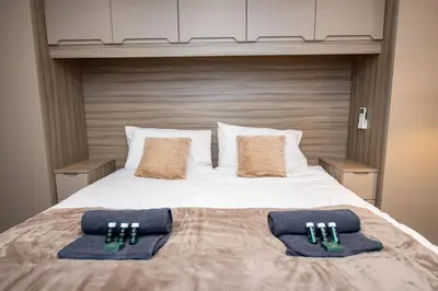 a bed with two pillows on top of it at Superb Location Stunning Luxury 4 Bedroom House in Liverpool