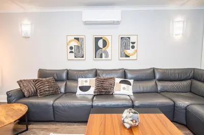 a leather couch in a living room with a table at Superb Location Stunning Luxury 4 Bedroom House in Liverpool