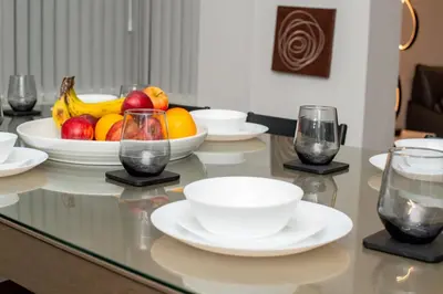 a table with plates and bowls of fruit on it at Superb Location Stunning Luxury 4 Bedroom House in Liverpool