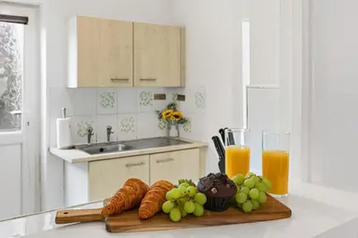 a kitchen counter with croissants and grapes and orange juice at Warm and Cosy Home at L6 Sleeps 5 in Liverpool