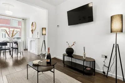 a living room with a tv on a white wall at Warm and Cosy Home at L6 Sleeps 5 in Liverpool