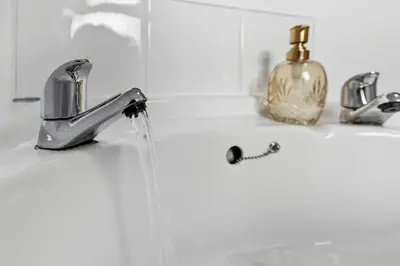 a bathroom sink with water running from a faucet at Warm and Cosy Home at L6 Sleeps 5 in Liverpool