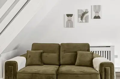 a brown couch in a room with a staircase at Warm and Cosy Home at L6 Sleeps 5 in Liverpool