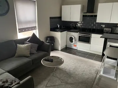 a living room with a couch and a kitchen at Cozy 1 bed apartment Blackpool in Blackpool