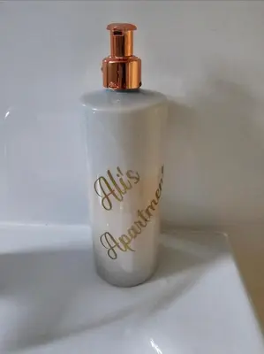 a white bottle with a gold top on a table at Cozy 1 bed apartment Blackpool in Blackpool
