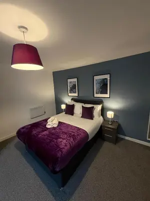 a bedroom with a large bed with a purple blanket at Spacious 4 Bedroom Apartment with Terrace Liverpool by StaySavvy Accommodation in Liverpool