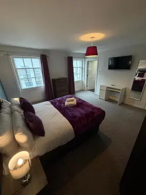 a bedroom with a large bed and a couch at Spacious 4 Bedroom Apartment with Terrace Liverpool by StaySavvy Accommodation in Liverpool