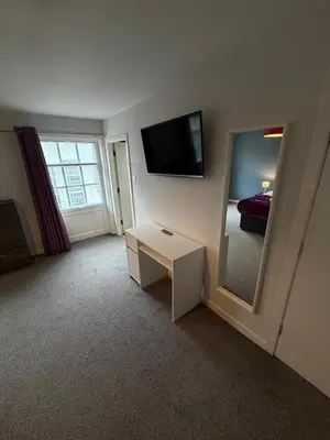 a room with a mirror and a tv and a bed at Spacious 4 Bedroom Apartment with Terrace Liverpool by StaySavvy Accommodation in Liverpool