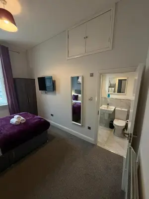 a bedroom with a purple bed and a bathroom at Spacious 4 Bedroom Apartment with Terrace Liverpool by StaySavvy Accommodation in Liverpool